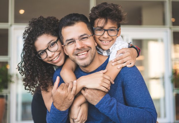 A man being hugged by his son and daughter