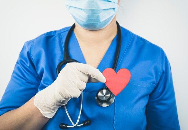 Profesional médico sosteniendo un corazón de papel