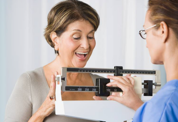 Woman smiling while being weighed