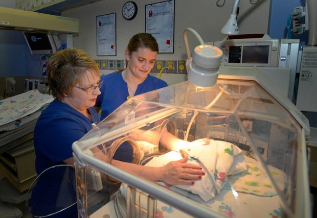 Nurses watch over baby in NICU