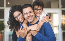 A man being hugged by his son and daughter