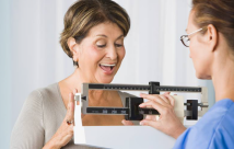 Woman smiling while being weighed