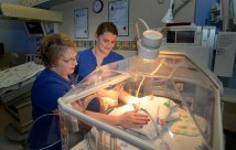 Nurses watch over baby in NICU